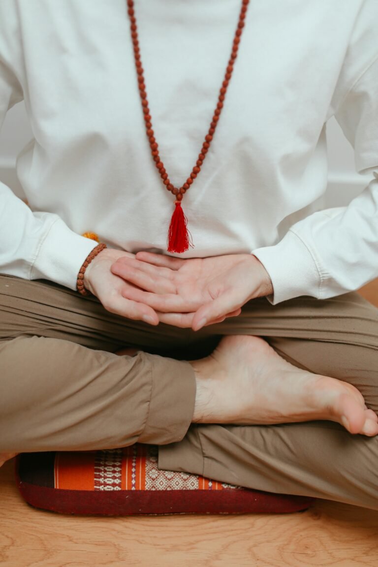 A person in a meditative pose with beads, focusing on relaxation and mindfulness.